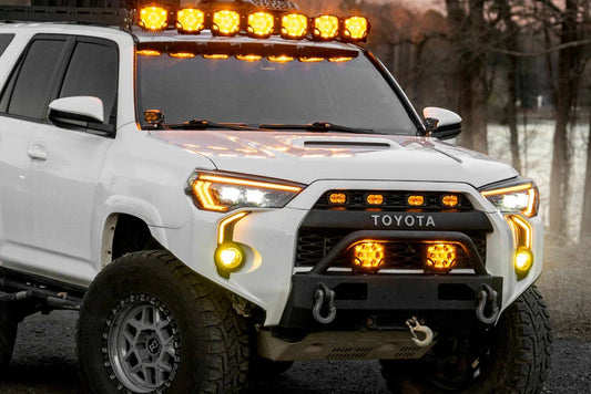 White 5th gen Toyota 4Runner with TRD Pro grille, amber lights and roof light bar